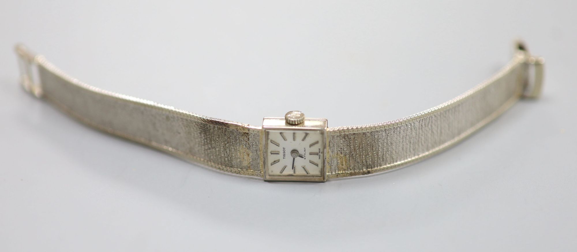 A ladys textured 9ct white gold Tissot manual wind bracelet wrist watch, overall length 17cm, gross 22 grams.